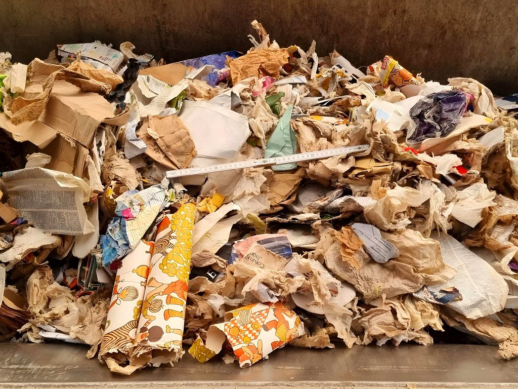 Photo_03_Paper_from_residual_waste,_loaded_into_a_wheel_loader_bucket_for_feeding_into_the_test_sorting_system